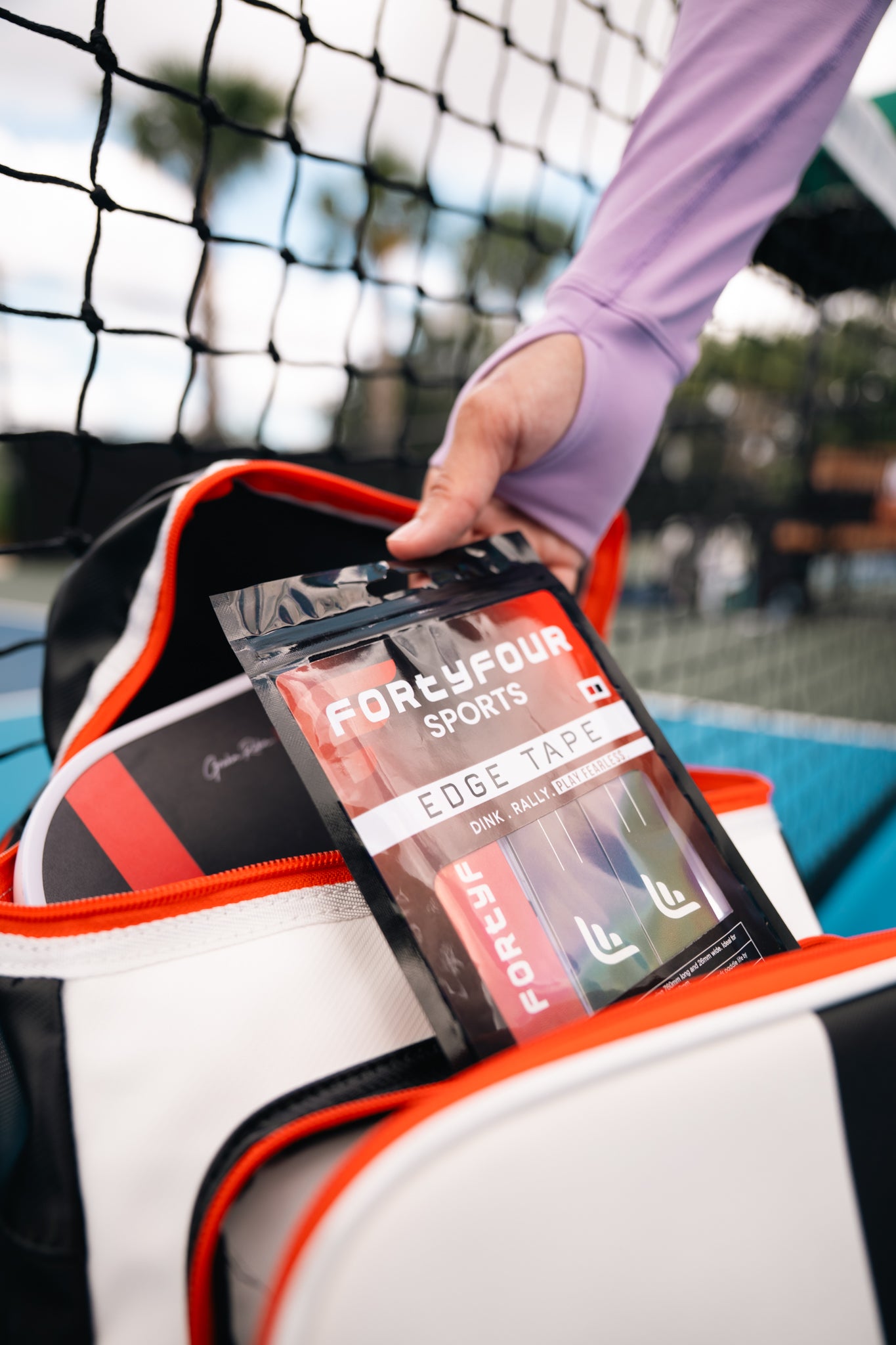 Inferno Edge Tape pack being pulled from a pickleball bag courtside