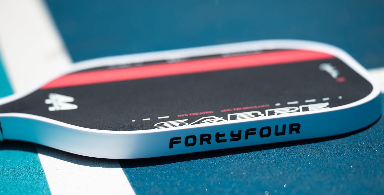 Competitive pickleball player using Fortyfour Sabre full foam core paddle for arm-friendly all-day performance