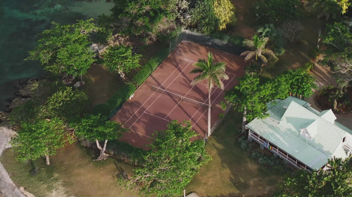 Aerial view of professional pickleball courts at a tropical resort with ocean views